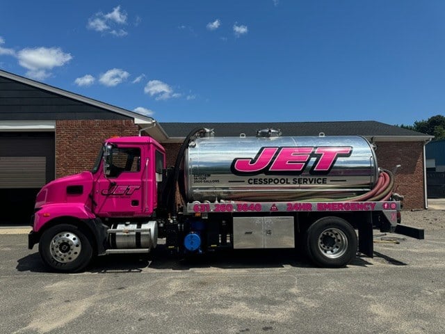 Side view of a JET Cesspool Service pump truck showing the 24-hour emergency number