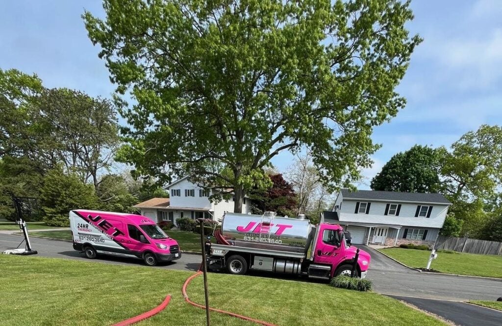 JET pink pump truck and service van parked on a tree-lined Long Island street