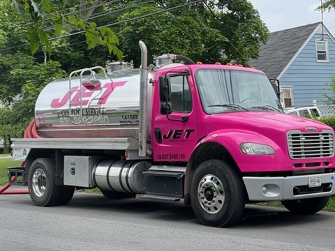 JET pink pump truck parked on a residential Long Island street