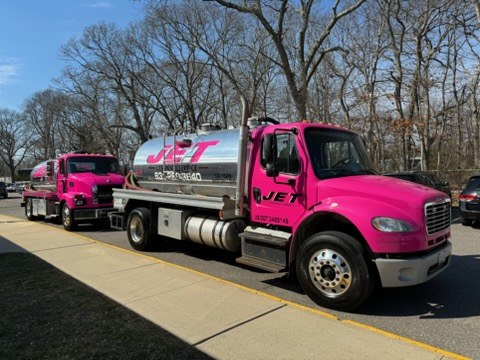 Two JET pink pump trucks parked on site